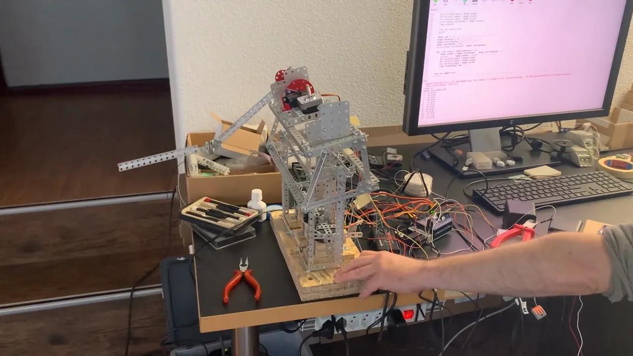 Testaufbau einer mechanischen Figurenbewegung mit Stokys-Bauteilen, Servo-Motoren, Verkabelung und Steuerung am Arbeitsplatz.
